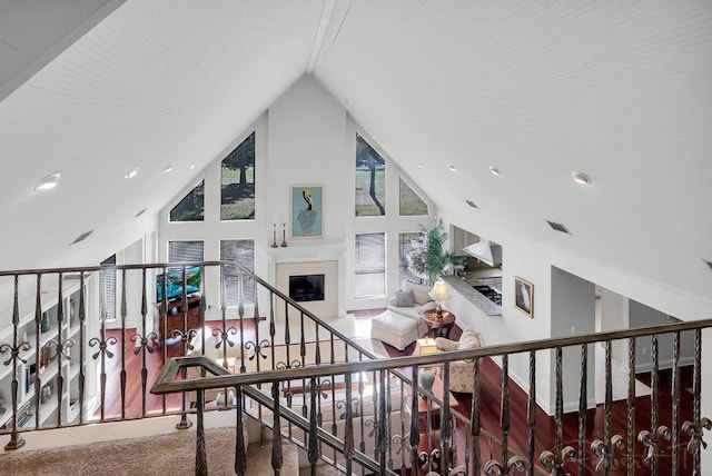 staircase featuring a fireplace and high vaulted ceiling