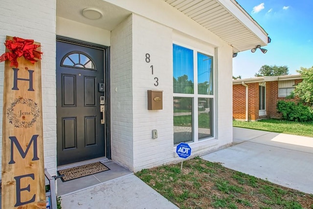 view of exterior entry with brick siding