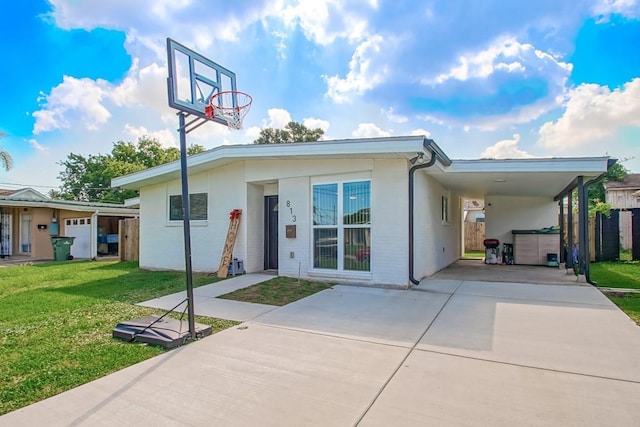 view of front of home featuring a front lawn, concrete driveway, a carport, and brick siding