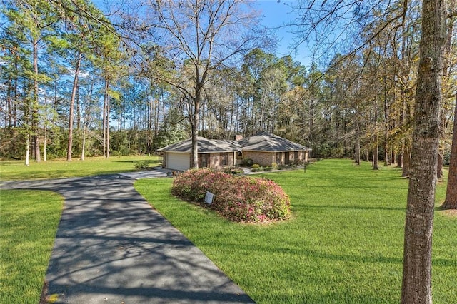 view of front of property with aphalt driveway, a garage, and a front yard