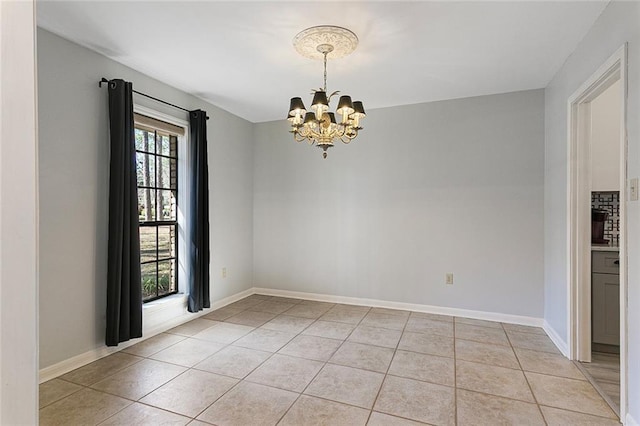 spare room featuring a notable chandelier, baseboards, and light tile patterned floors