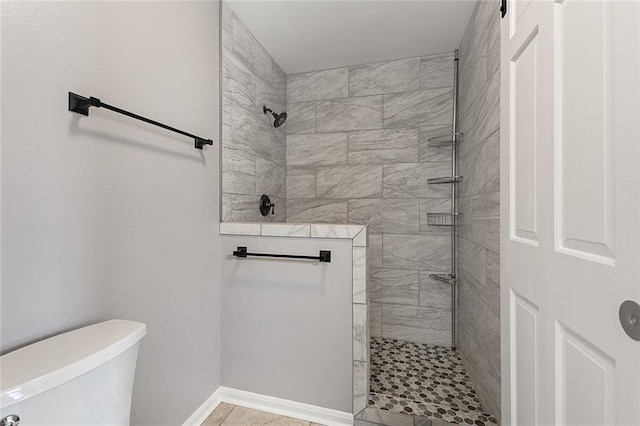 bathroom with baseboards, toilet, and walk in shower