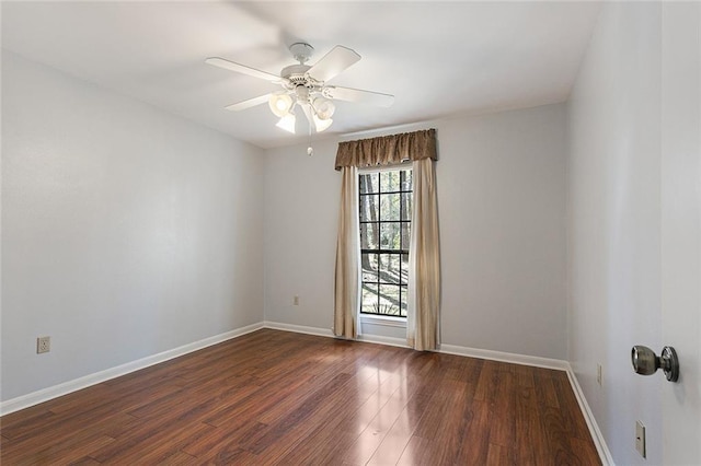 spare room featuring wood finished floors, baseboards, and ceiling fan