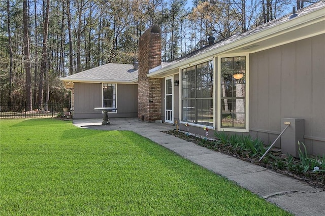 exterior space with a patio, a yard, fence, and a chimney