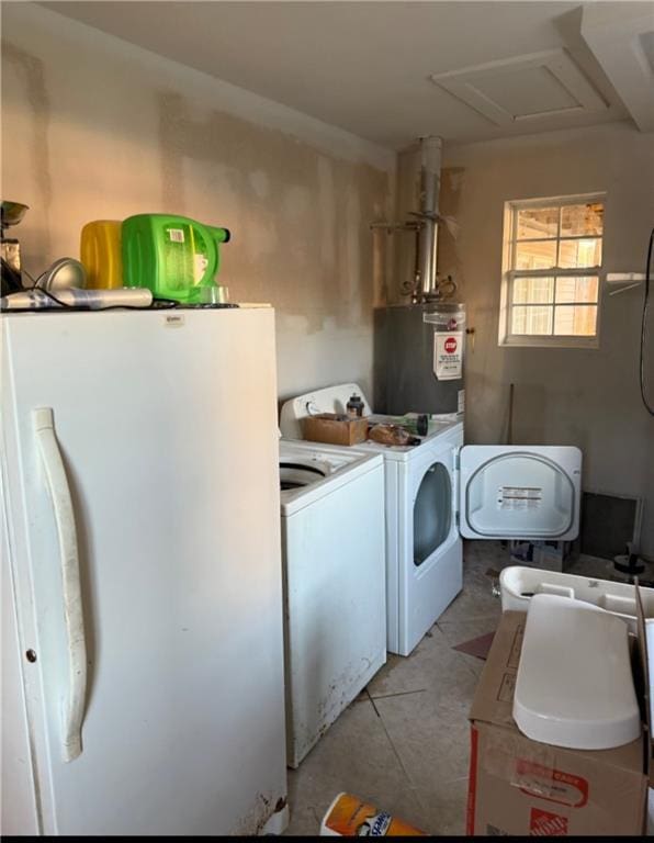 washroom with water heater, laundry area, and washer and clothes dryer