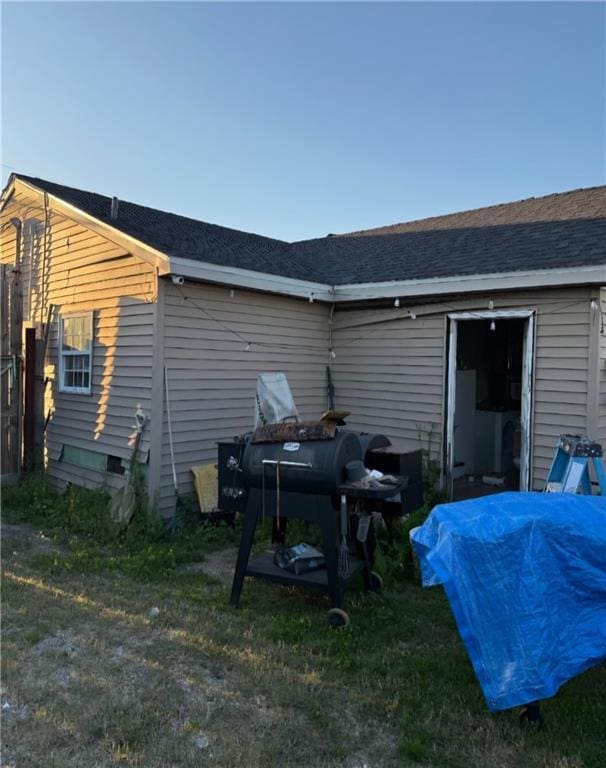 back of property featuring a shingled roof