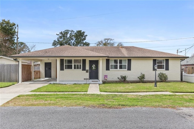 single story home with fence, concrete driveway, a front lawn, a carport, and brick siding