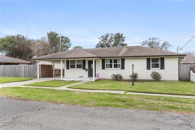 ranch-style home with driveway, a front lawn, an attached carport, fence, and brick siding