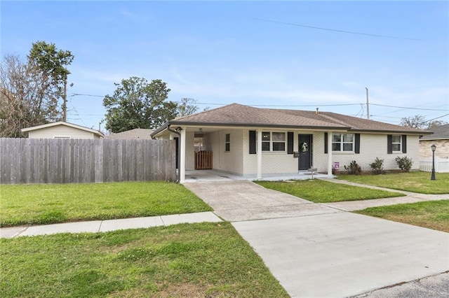 view of front of home featuring a front lawn, driveway, fence, roof with shingles, and an attached carport