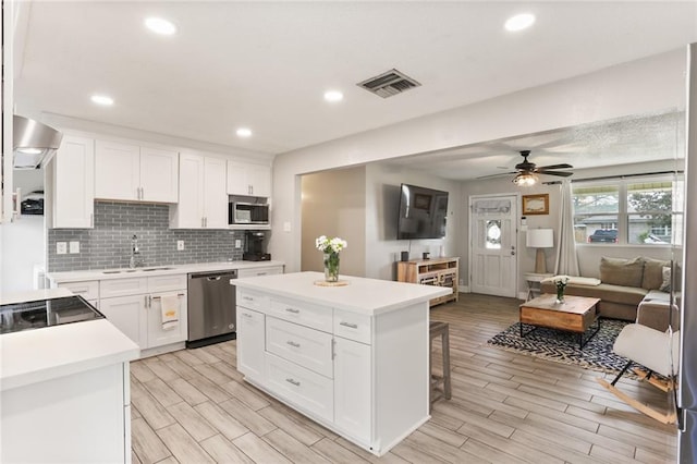 kitchen featuring tasteful backsplash, visible vents, light countertops, appliances with stainless steel finishes, and a sink