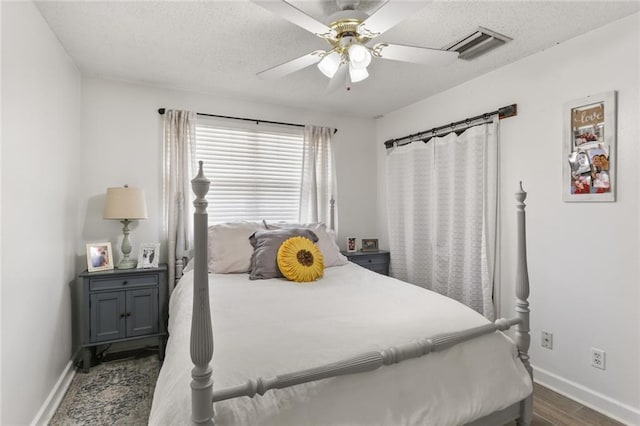 bedroom featuring visible vents, a textured ceiling, and baseboards