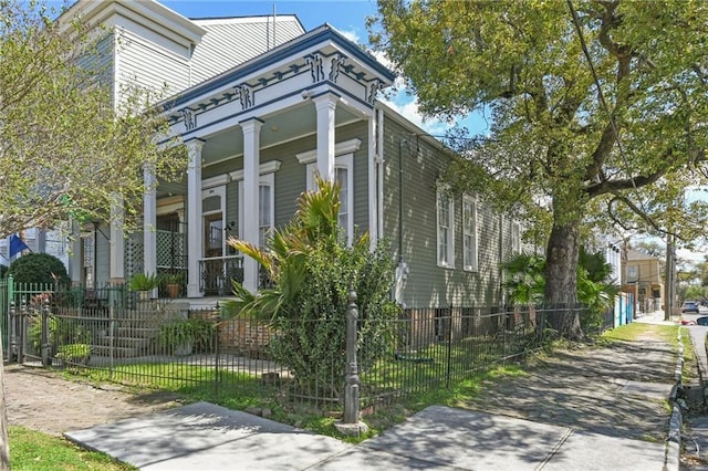 view of property exterior featuring a fenced front yard and covered porch