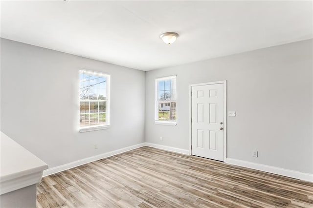 empty room with baseboards and wood finished floors