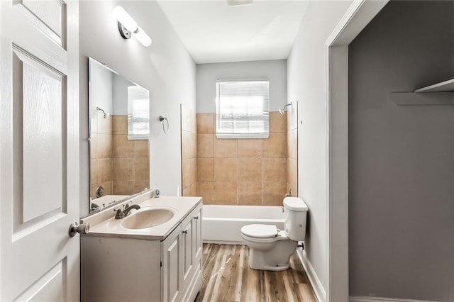 bathroom featuring vanity, washtub / shower combination, toilet, and wood finished floors