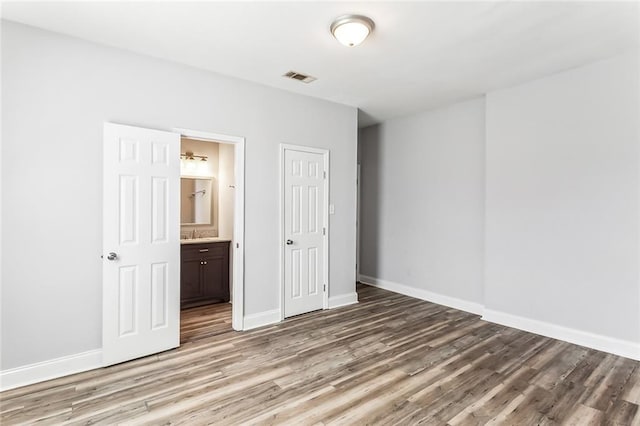 unfurnished bedroom with visible vents, baseboards, light wood-style floors, a closet, and connected bathroom