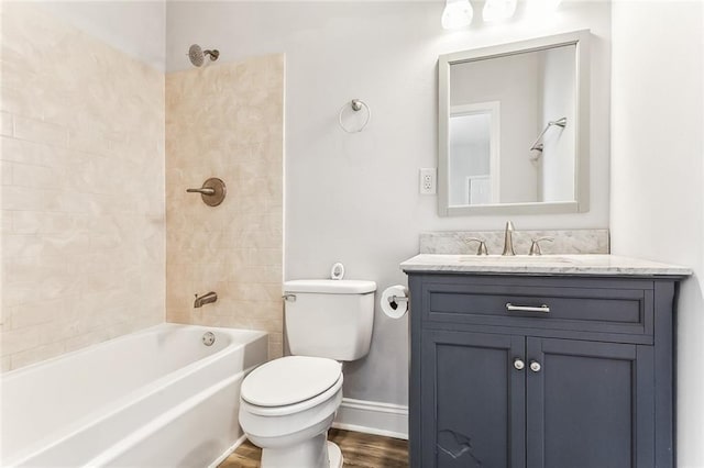 bathroom with toilet, wood finished floors, baseboards, bathing tub / shower combination, and vanity