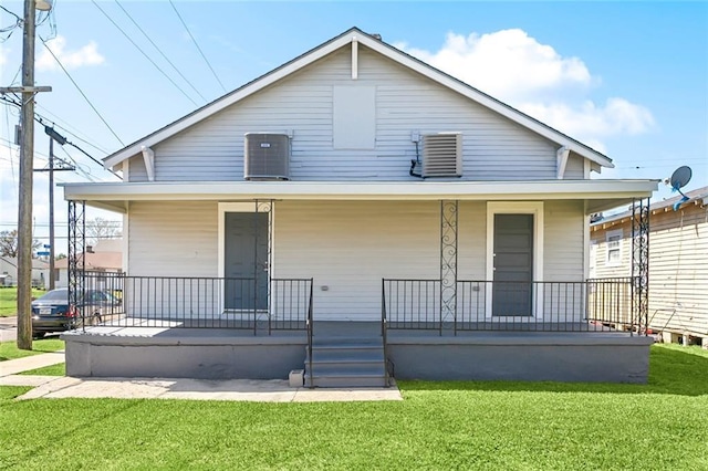 view of front of property with covered porch, cooling unit, and a front yard