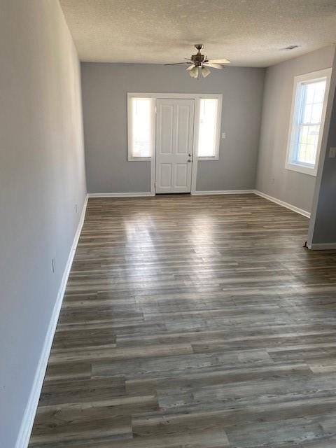 unfurnished room featuring a textured ceiling, wood finished floors, baseboards, and ceiling fan