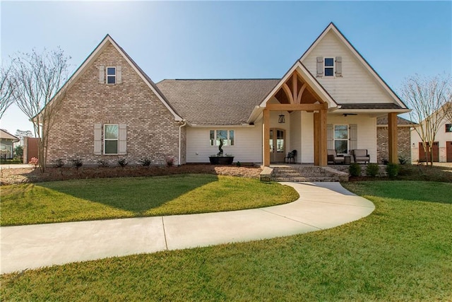 view of front of home featuring brick siding, covered porch, and a front lawn