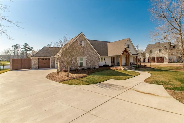 view of front of house with a front lawn, concrete driveway, covered porch, an attached garage, and a gate