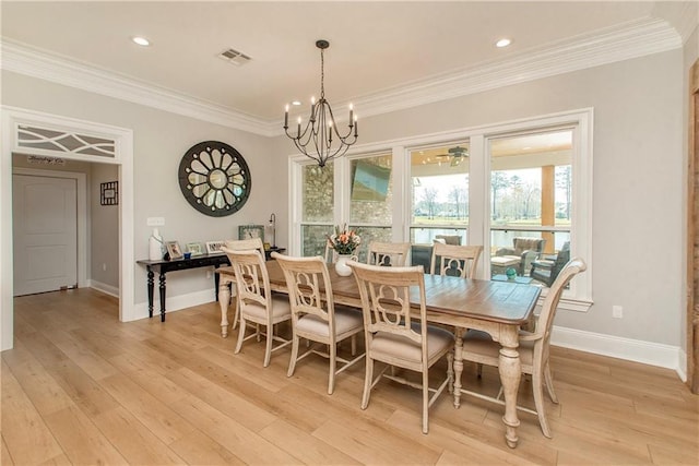 dining room with light wood-style flooring, ornamental molding, visible vents, and a chandelier