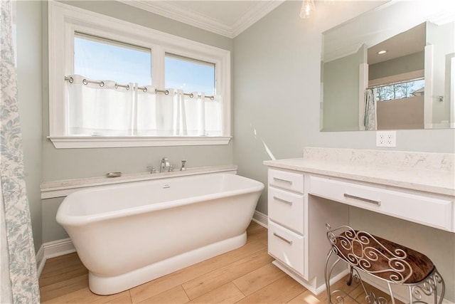 full bath featuring crown molding, wood finished floors, baseboards, and a freestanding bath