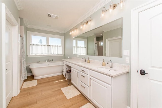 full bathroom with a sink, visible vents, wood finished floors, and ornamental molding