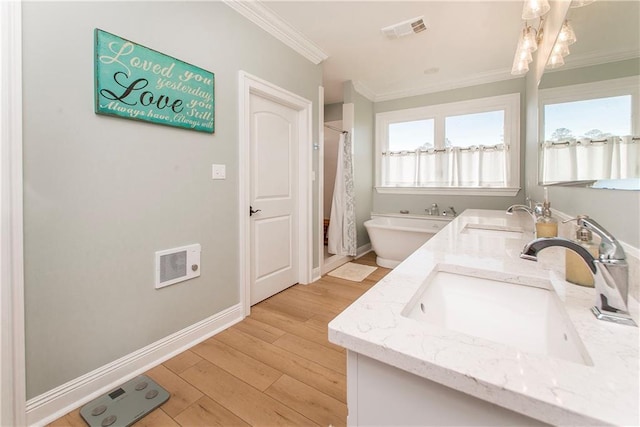 bathroom with a sink, visible vents, wood finished floors, and crown molding