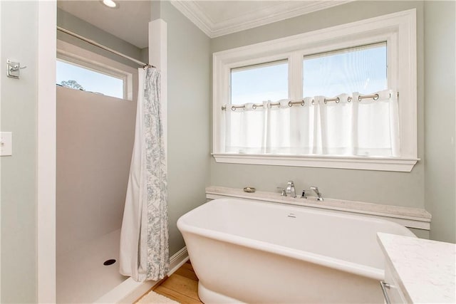 bathroom with a stall shower, ornamental molding, wood finished floors, a soaking tub, and vanity