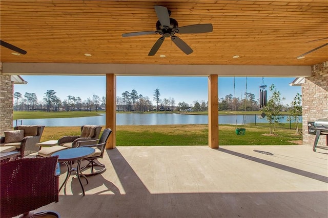 view of patio with ceiling fan and a water view