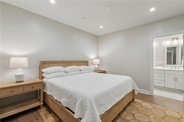 bedroom with recessed lighting, a sink, light wood-style flooring, and ensuite bathroom