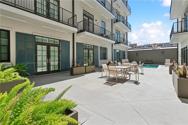 view of patio with a fenced in pool and french doors