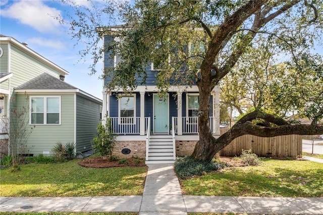 view of front of home featuring a porch, a front lawn, and crawl space