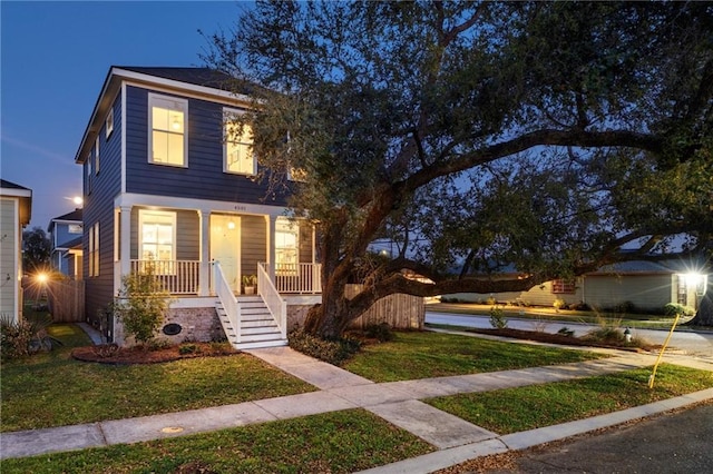 view of front of home with covered porch and a front lawn