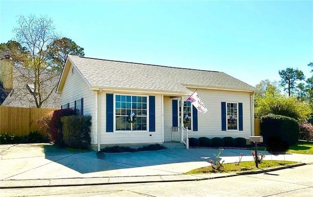 view of front of house with roof with shingles and fence