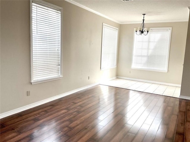 unfurnished room featuring a notable chandelier, wood finished floors, and crown molding