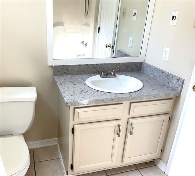 half bath with baseboards, toilet, vanity, and tile patterned flooring