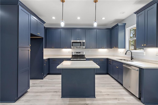 kitchen featuring blue cabinetry, a center island, light wood-style flooring, stainless steel appliances, and a sink