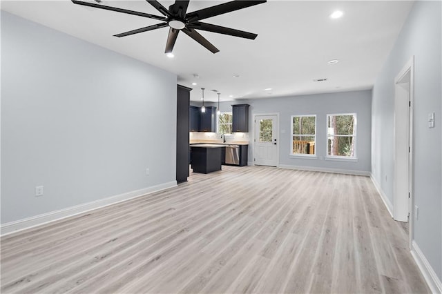 unfurnished living room with recessed lighting, a ceiling fan, light wood-type flooring, and baseboards