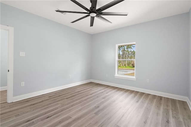 spare room with baseboards, a ceiling fan, and light wood finished floors