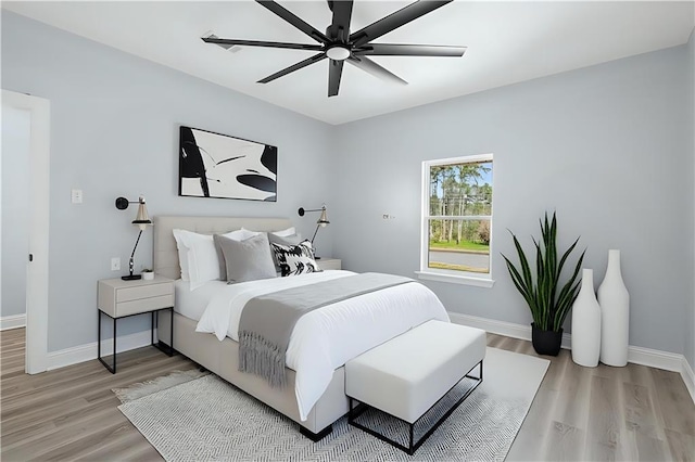 bedroom with baseboards, a ceiling fan, and light wood finished floors