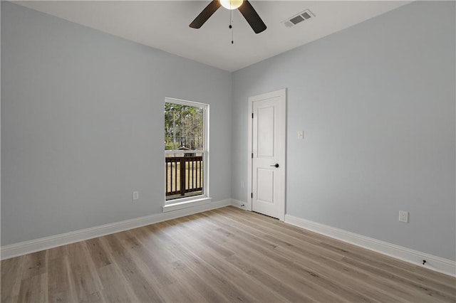 spare room with baseboards, a ceiling fan, visible vents, and light wood-type flooring