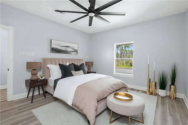 bedroom with light wood-type flooring, baseboards, and ceiling fan