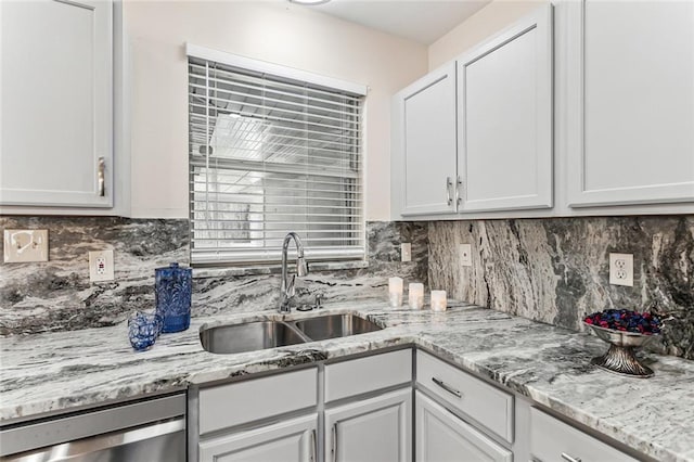 kitchen with dishwasher, light stone countertops, tasteful backsplash, and a sink