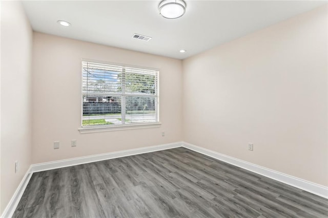 empty room featuring recessed lighting, visible vents, baseboards, and dark wood finished floors