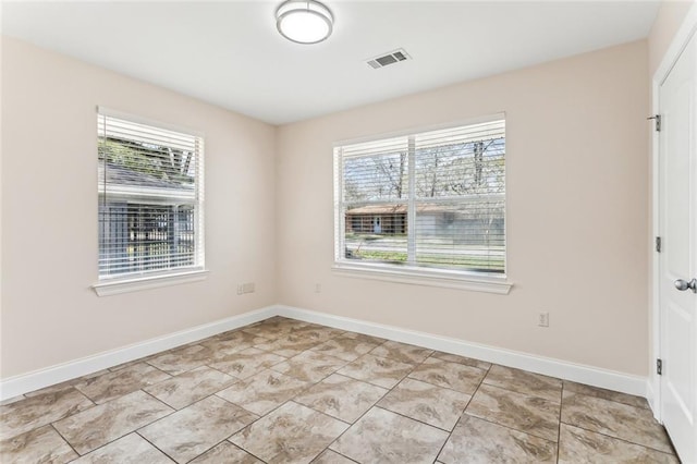 empty room with visible vents, baseboards, and a healthy amount of sunlight