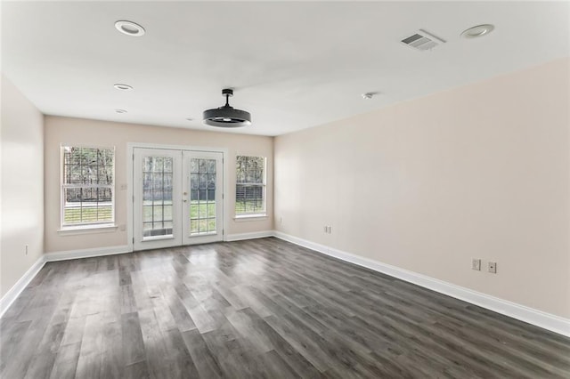 empty room with dark wood-type flooring, baseboards, and a wealth of natural light