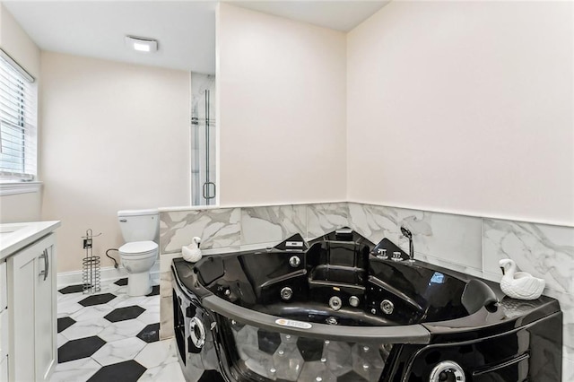 full bathroom featuring a stall shower, toilet, vanity, and a whirlpool tub