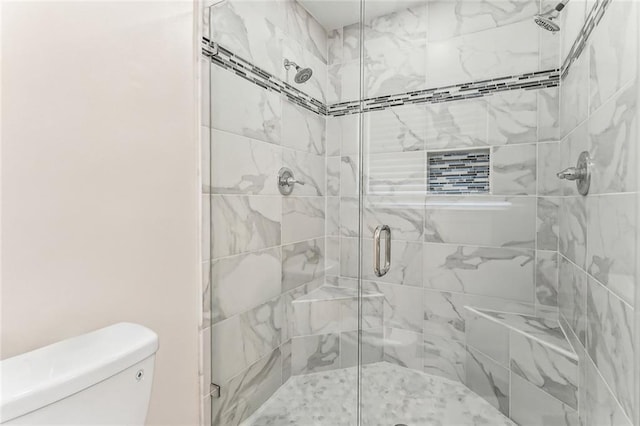 bathroom featuring a shower stall and toilet