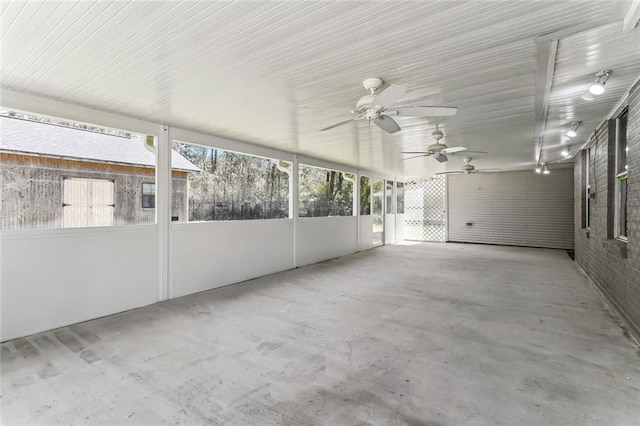 unfurnished sunroom with a wealth of natural light and a ceiling fan